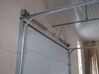 Garage Door Installation Process in Blaine MN Interior view of a newly installed sectional garage door with metal tracks and opener system in a Blaine, Minnesota garage.