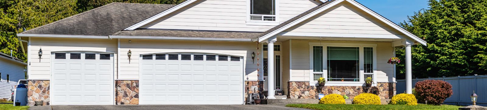 White suburban house with double garage doors and well-kept landscaping in Minnesota.